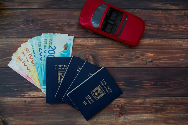 Προετοιμασία για ένα ταξίδι στο Ισραήλ, κόκκινο αυτοκίνητο, χρήματα, διαβατήριο στο ξύλινο τραπέζι — Φωτογραφία Αρχείου
