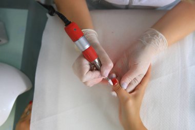 Eski jel tırnak tırnak salonu bir çivi değirmeni ile onarmak. Eski jel çivi yenileri ile değiştirme işlemi