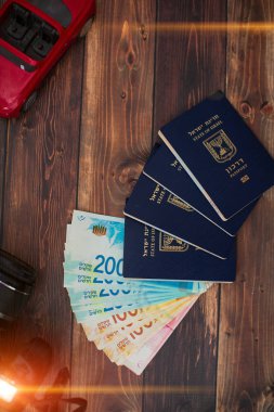 İsrail para faturaları 200 şikel ve ahşap bir masa üzerinde İsrail pasaportu miktarı yığını