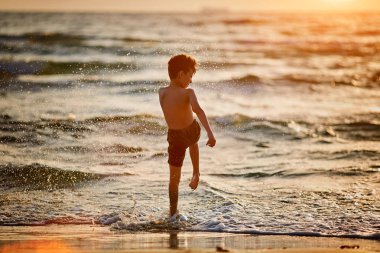 gün batımında denize atlama mutlu küçük çocuk silüeti