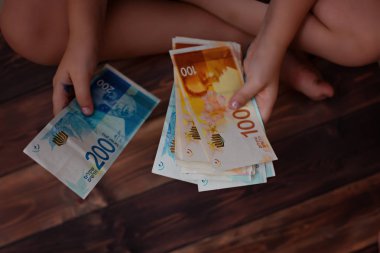 Ödeme karşılığı, çocukların iki el holding İsrail banknotlar 200, 100 şekel ILS kavramı