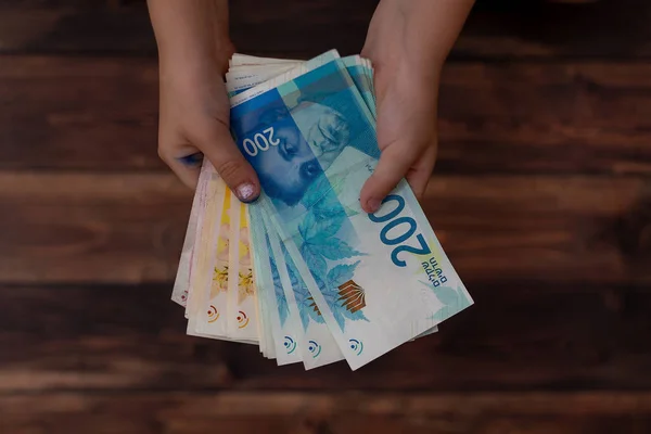 Little girl counts the money, 100, 200 shekels — Stock Photo, Image