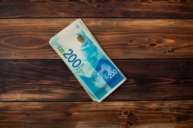 Ahşap arka plan üzerinde 200 İsrail Yeni Şekeli değer birkaç yeni banknotlar