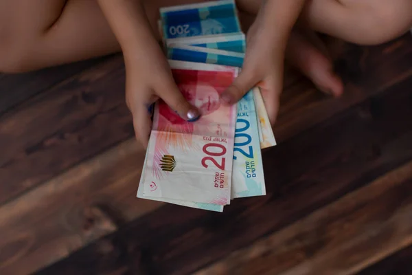 Little girl counts the money, 100, 200 shekels — Stock Photo, Image