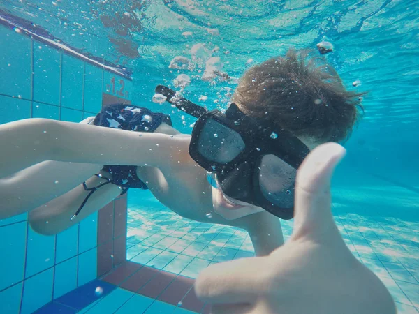 ゴーグル付きのスイミング プールの水中少年楽しみ。夏の休暇の楽しみ — ストック写真