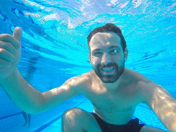 Retrato submarino del hombre sonriente. Persona divirtiéndose en la piscina. Concepto vacaciones de verano — Foto de Stock