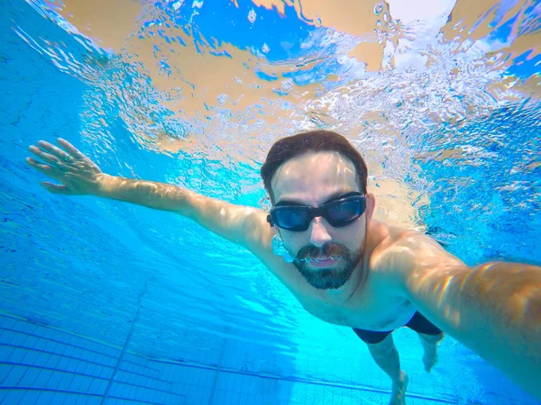 Mann schwimmt im Resort unter Pool. — Stockfoto
