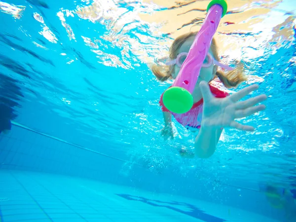 Feliz niño activo bajo el agua nada en la piscina, hermosa niña sana nadando y divirtiéndose en las vacaciones de verano familiares, deporte de los niños —  Fotos de Stock