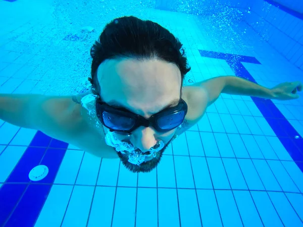 Jovem homem barbudo sexy com cabelo molhado e barba nadando na piscina — Fotografia de Stock