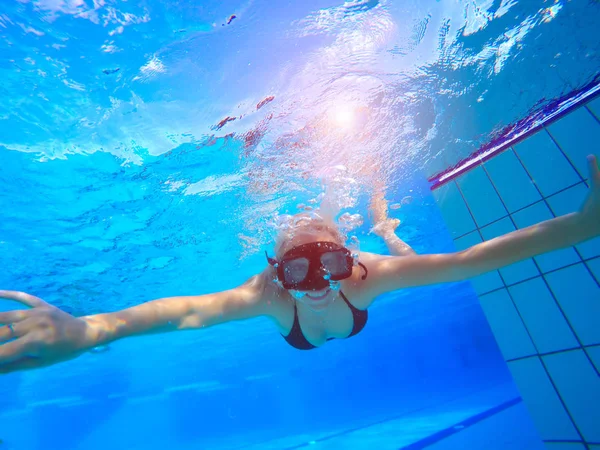 Jovem nadando subaquático na piscina — Fotografia de Stock