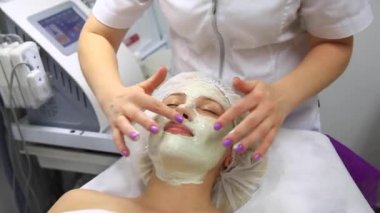 Yüz soyma maskesi, kaplıca güzellik tedavisi, cilt bakımı. Güzellik salonundaki kadın yüz bakımını alıyor. Yan görüş, yakın çekim.