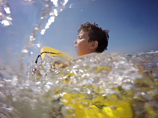 Jovem surfista remando pelo oceano — Fotografia de Stock