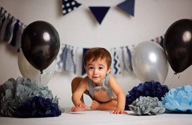 İlk Doğum günü kutluyor mutlu bebek çocuk. Çocukların Doğum günü partisi dekore edilmiş balonlar ve renkli afiş