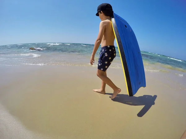 10 代の少年がアジアの熱帯のビーチでサーフィン — ストック写真