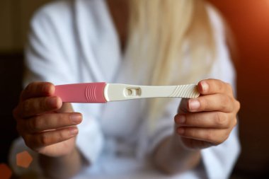 Pozitif gebelik testi tutan eller kadın