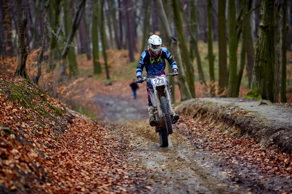 Mann rast mit Motorrad in Herbstwald Unscharfer Hintergrund ist in Bewegung — Stockfoto