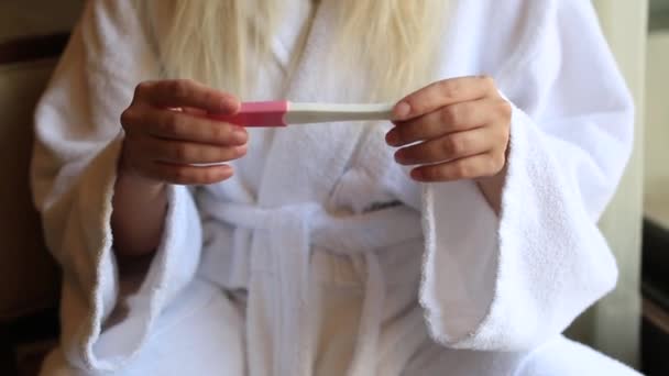 Mãos femininas segurando teste de gravidez, girando para mostrar duas linhas, planejamento familiar — Vídeo de Stock