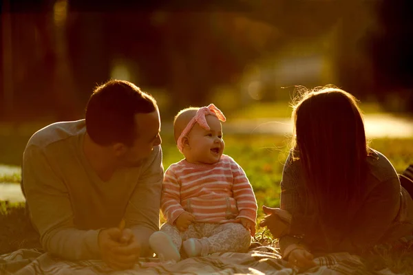 Familia feliz teniendo un picnic en el jardín verde — Foto de Stock