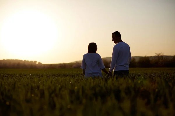 Mladý pár se drží za ruce. V přírodě sunrise, vintage tón — Stock fotografie