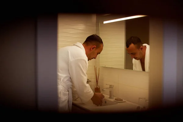 男はバスルームに彼の顔に立ってを洗う — ストック写真