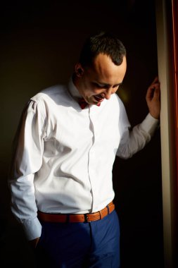 Genç Amerikalı adam dışında kahverengi deri ayakkabılar, Manhattan, New York, giyen Beyaz tişört, Mavi pantolon, düşünme, üzgün seyir ceplerinde, windows ile duvar karşı ayakta eller