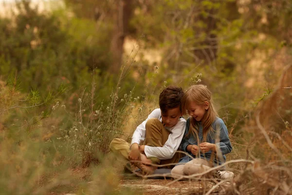 Kinder sitzen in der Natur auf dem Boden — Stockfoto