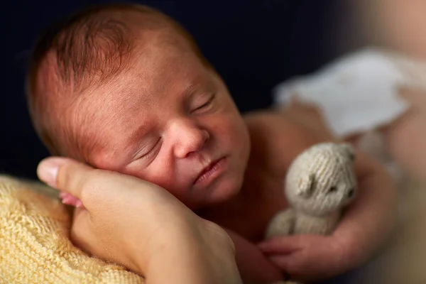 愛らしいの生まれたばかりの赤ちゃんがおもちゃで睡眠中に仰向けになって母の手のクローズ アップ — ストック写真