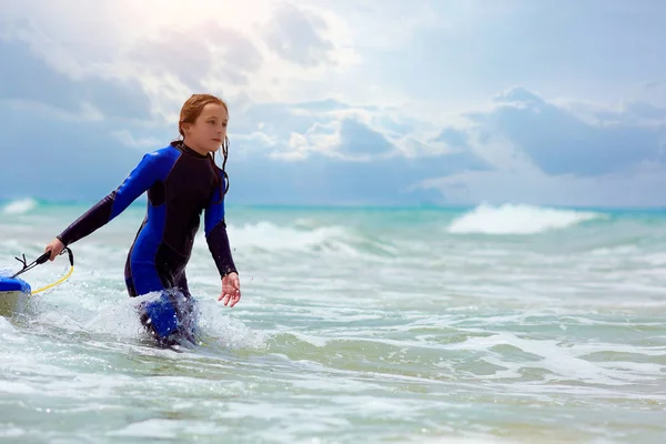 Mädchen mit Surfbrett läuft im Meer — Stockfoto