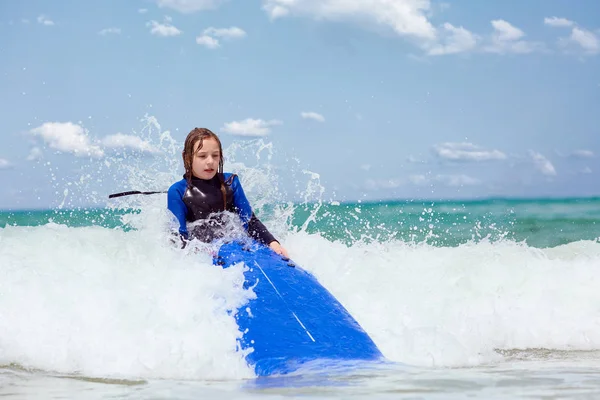 Хвилі блимають біля дівчини з дошкою для серфінгу — стокове фото
