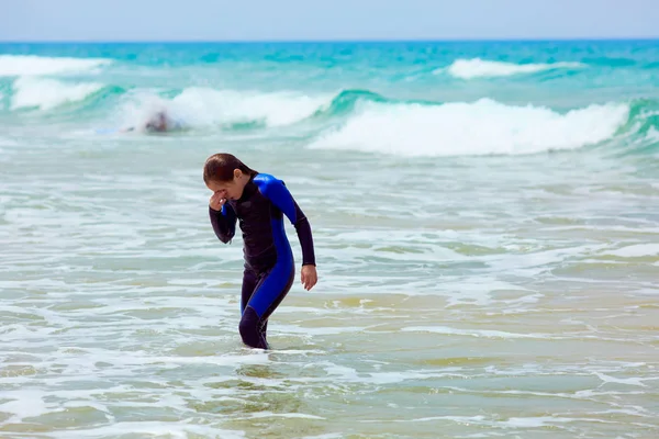 Menina esfregando os olhos no mar ondulando — Fotografia de Stock