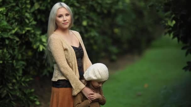 Madre con una figlia di cinque anni camminano insieme in una piantagione di arance. Concetto di amore familiare per la natura. Colpo al rallentatore — Video Stock