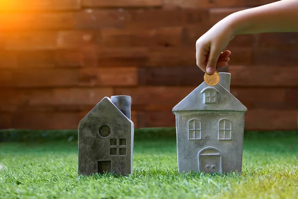 Main mettant pièce en forme de maison tirelire pour économiser de l'argent à l'achat d'une maison — Photo