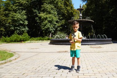 Genç çocuk selfie Eylem Kamera açık ve bir kaktüs arka planda alarak. Eylem cam bahçede oynarken beyaz pre teen