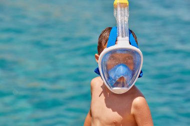 Çocuk yüzüne şnorkel maskesi ve tüp closeup. Seyahat ve yaz konsepti