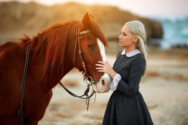 Drömmande skott av en kvinna med en häst nära havet — Stockfoto