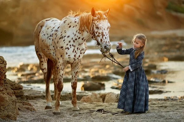 Flicka i klänning promenader med häst — Stockfoto