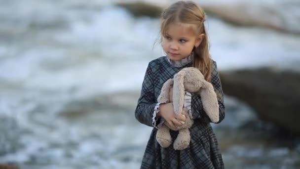 Menina no vestido segurando coelho brinquedo na natureza hd completo — Vídeo de Stock