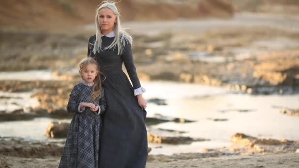 Küçük kız ve annesi deniz arka plan üzerinde gün batımında soyluları vintage elbiseler — Stok video