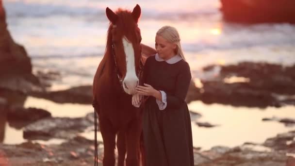 Kvinna med häst på steniga havsstrand — Stockvideo