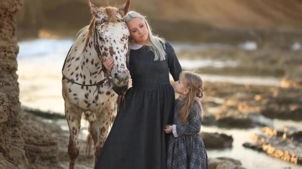 Terapia con caballos. Mujer con una hija cuidando de su caballo. cámara lenta full hd — Vídeo de stock