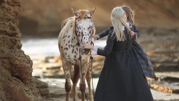 Терапия лошадьми. Женщина с дочерью, ухаживающей за лошадью. Полная тишина — стоковое видео