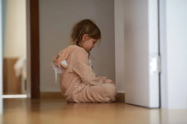 Açık kapı evde yakın katta oturan pijama sevimli üzgün kız yan görünüm