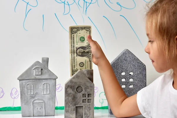 Opslaan van geld childs hand zet één Amerikaanse dollar in het huis — Stockfoto