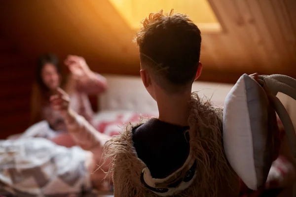 Mamá y su hijo juegan en la cama, por la mañana organizar una pelea de almohadas en su pijama —  Fotos de Stock