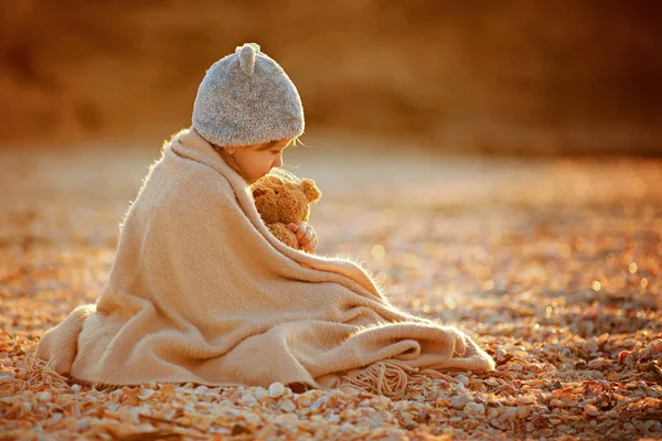 Flicka med leksak Gos i rutigt på stranden — Stockfoto