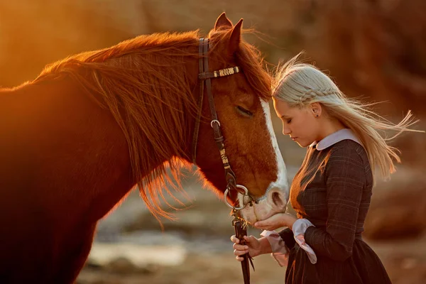Kvinna med häst på steniga havsstrand — Stockfoto