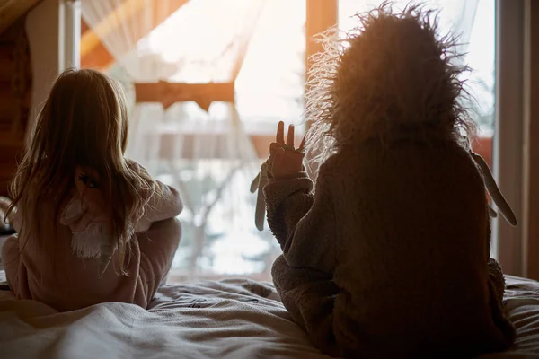 Niños en trajes acogedores en la cama —  Fotos de Stock