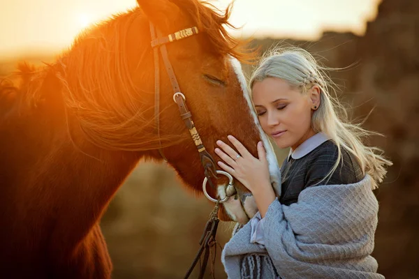 Kvinna som omfamnar hästhuvud i naturen — Stockfoto