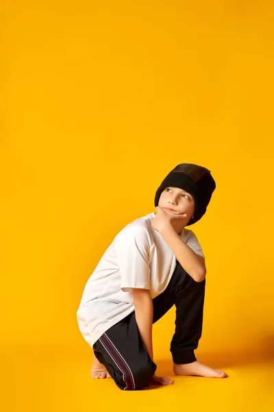 Young man break dancing on yellow background