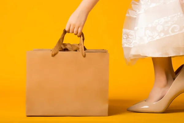 Девушка в огромных ботинках берет бумажный пакет, концепцию покупок — стоковое фото